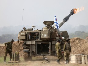 An Israeli army self-propelled artillery howitzer fires rounds