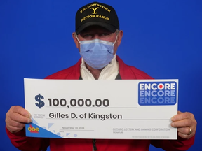Gilles Dupuis, 66, of Kingston with his $100,000 cheque at the OLG Prize Centre in Toronto on Dec. 1, 2023