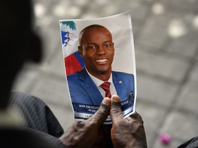 A person holds a photo of late Haitian President Jovenel Moise during his memorial ceremony at the National Pantheon Museum in Port-au-Prince, Haiti, July 20, 2021.