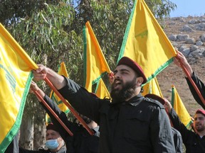 Members of the Lebanese Shiite Hezbollah movement raise party flags as they mark an annual commemoration of a suicide attack against Israeli forces in the Marjayoun region of southern Lebanon, on Nov. 11, 2021.