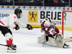 Canada's Macklin Celebrini scores on Latvia goaltender Linards Feldbergs during second-period preliminary round hockey action at the IIHF World Junior Hockey Championship in Gothenburg, Sweden, Wednesday, Dec. 27, 2023.