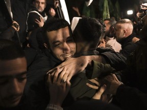 A man smiles as he is welcomed after being released from prison by Israel, Thursday, Nov. 30, 2023, in the West Bank town of Ramallah.