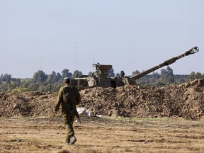 An Israeli soldier walks neare a self-propelled artillery howitzer in southern Israel near the border with the Gaza Strip on Dec. 16, 2023, amid ongoing battles between Israel and the Palestinian militant group Hamas.