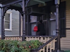 A screengrab of video posted to X by WSB-TV of a woman pouring gasoline on the Martin Luther King House.