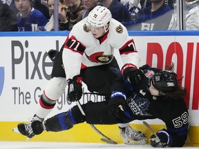 Ottawa Senators' Ridly Greig checks Maple Leafs' Tyler Bertuzzi during the first period in Toronto on Wednesday, Dec. 27, 2023.