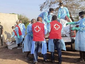 workers from the Liberia National Red Cross Society and the Bong County Health Team move the bodies of victims