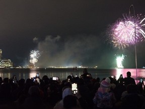 People watch the New Year's fireworks display over Toronto's inner harbour from Ireland Park after midnight, on Jan. 1, 2023. (The Canadian Press)