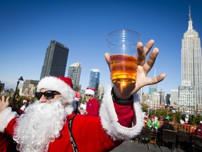 A man dressed as Santa Claus holds a beer as he and others participate in SantaCon