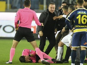 Referee Halil Umut Meler holds his face as he lies on the ground after being punched by MKE Ankaragucu president Faruk Koca, center, at the end of the Turkish Super Lig soccer match between MKE Ankaragucu and Caykur Rizespor in Ankara, Monday, Dec. 11, 2023. Faruk Koca, the former president of a Turkish top division soccer team who was jailed for punching a referee, has been released on bail, the country's state-run news agency reported on Wednesday, Dec. 27, 2023.