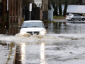 A car drives through a flooded street after a large rainstorm on Dec. 18, 2023 in Paterson, N.J.