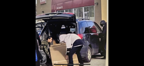 Alleged thieves load goods from an electronics store in Scarborough into a minivan. An off-duty Toronto Police officer was stabbed in the wrist. SUPPLIED PHOTO