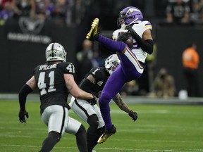 Minnesota Vikings wide receiver Justin Jefferson (18) makes a catch as Las Vegas Raiders safety Marcus Epps (1) defends during the first half of an NFL football game, Sunday, Dec. 10, 2023, in Las Vegas.