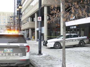 Winnipeg Police vehicles and police tape outside of the Cargill Building in the 200 block of Graham Avenue in downtown Winnipeg on Saturday, Dec. 16, 2023. A teenage girl died following a stabbing on Friday at around 1 p.m., in the 200 block of Graham Avenue. She was rushed to hospital in critical condition and underwent emergency surgery but she succumbed to her injuries. The Homicide Unit is investigating.
