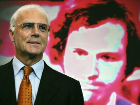 Franz Beckenbauer (R) poses in front of a portrait of himself in 2006.