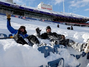 Workers pose as they clear snow from bleacher seats before the game between the Pittsburgh Steelers and the Buffalo Bills at Highmark Stadium.