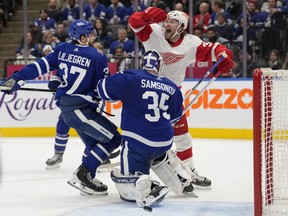 Detroit Red Wings' Christian Fischer celebrates a late go-ahead goal by teammate Lucas Raymond, not shown, as Toronto Maple Leafs goalie Ilya Samsonov and Timothy Liljegren react.