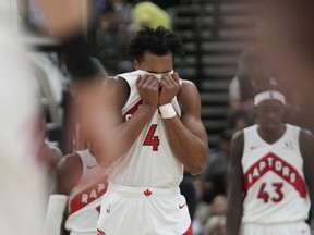 Toronto Raptors forward Scottie Barnes covers his face as he heads to the bench.
