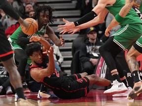 Toronto Raptors forward Thaddeus Young (21) tries to make a pass from the floor as Boston Celtics guard Jrue Holiday (4) defends.