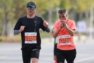 Chinese runner Uncle Chen lights a cigarette while running.