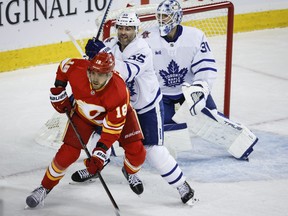 Toronto Maple Leafs defenceman Mark Giordano (55) checks Calgary Flames forward A.J. Greer.