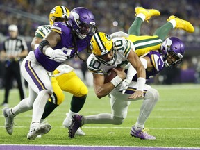 Jordan Love #10 of the Green Bay Packers dives for a touchdown during the second quarter against the Minnesota Vikings at U.S. Bank Stadium on December 31, 2023 in Minneapolis, Minnesota. (Photo by David Berding/Getty Images)