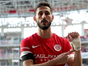 This handout photograph taken and released by Turkish news agency DHA (Demiroren News Agency) shows Antalyaspor's Israeli forward Sagiv Jehezkel displaying a bandage on his wrist reading "100 days. 07/10" after scoring a goal during Turkish Super league match between Antalyaspor and Trabzonspor at Corendon Airlines Park Antalya Stadium, in Antalya on January 14, 2024. (Demiroren News Agency)/AFP via Getty Images)