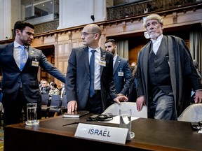 Israel Deputy Attorney-General for International Affairs Gilad Noam (C) and lawyer Malcolm Shaw (R) arrive at the International Court of Justice (ICJ) prior to the verdict announcement in the genocide case against Israel, brought by South Africa, in The Hague on January 26, 2024. (Photo by REMKO DE WAAL/ANP/AFP via Getty Images)