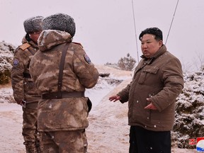 Kim Jong Un inspects a test firing of a missile.