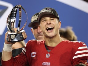 Brock Purdy of the San Francisco 49ers reacts as he holds the George Halas Trophy.