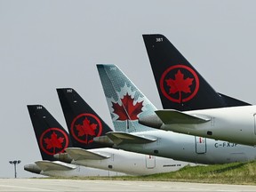 Air Canada planes sit on the tarmac.