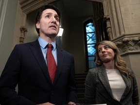 Canada's Minister of Foreign Affairs Melanie Joly looks on as Prime Minister Justin Trudeau speaks to reporters before caucus in Ottawa on Wednesday, Nov. 22, 2023.