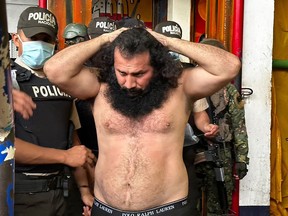 Handout picture released by the Ecuadorean Armed Forces showing Adolfo Macias, aka Fito, leader of the Los Choneros criminal gang, while being transferred to The Rock maximum-security complex inside the Zonal Penitentiary No 8 in Guayaquil, Ecuador, during a joint operation by the Police and the Military at the facility, Ecuador, on Aug. 12, 2023.