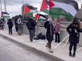 Demonstrators protest on the Avenue Rd. highway overpass in Toronto on Saturday, Jan. 6, 2024.