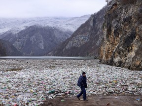 A crane operator walks next to the waste footing in the Drina river near Visegrad, Bosnia, Wednesday, Jan. 10, 2024.