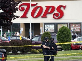 Police secure an area around a supermarket where several people were killed in a shooting, May 14, 2022 in Buffalo, N.Y.