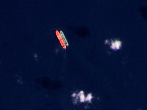 In this satellite photo provided by Planet Labs PBC, vessels identified as the Virgo, left, and the Suez Rajan, by the advocacy group United Against Nuclear Iran, are seen in the South China Sea on Feb. 13, 2022. (Planet Labs PBC via AP, File)