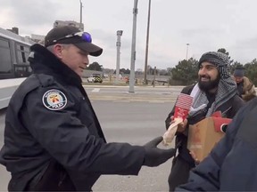 police officer hands coffee to protester