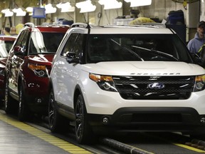 Workers perform final inspection as 2015 Ford Explorers roll off the assembly line at the Chicago Ford Assembly Plant in Chicago, Oct. 22, 2014. (AP Photo/M. Spencer Green, File)