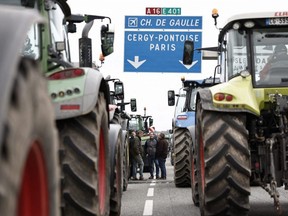 French farmers stop their tractors on the A16 motorway near L'Isle-Adam, on Tuesday, Jan. 30, 2024, as French farmers maintain roadblocks on key highways into Paris for a second day, increasing pressure on the government for more concessions on pay, tax and regulations.