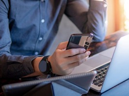 Businessman using a smartphone and laptop while working in the cafe.