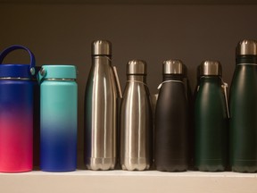 Several ecofriendly reusable water bottles placed on a shelf.