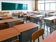 Empty classroom with desks, chairs and chalkboard