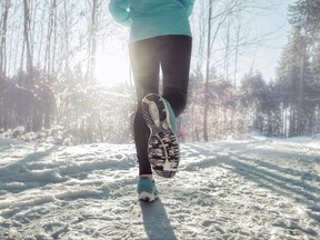 Woman Running at snowly winter under sunlight.