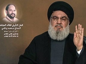 An image grab from Hezbollah's al-Manar TV taken on Jan. 5, 2024, shows the head of the Lebanese Shiite movement Hezbollah Hassan Nasrallah delivering a televised speech, with a picture of killed Hamas's deputy chief Saleh al-Aruri to his left.
