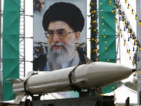 Iranian missile on display in front of a large portrait of Iran's Supreme Leader Ayatollah Ali Khamenei