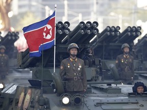 North Korean soldiers stand on armoured vehicles with rocket launchers as they parade in Pyongyang, North Korea, on Oct. 10, 2015.