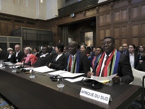Ambassador of the Republic of South Africa to the Netherlands Vusimuzi Madonsela, right, and Minister of Justice and Correctional Services of South Africa Ronald Lamola, centre, during the opening of the hearings at the International Court of Justice in The Hague, Netherlands, Thursday, Jan. 11, 2024.