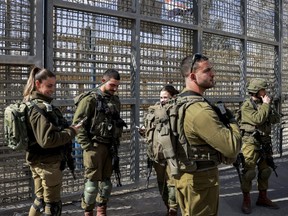 Israeli army soldiers stand next to the border fence with Egypt at the Nitzana border crossing in southern Israel on Tuesday, Jan. 30, 2024.