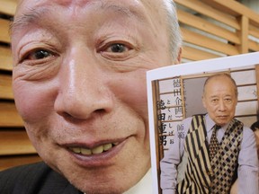 Porno video actor Shigeo Tokuda smiles as he shows an advertisement poster of his video at a Tokyo video shop on March 5, 2009.