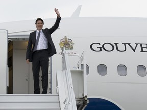 Justin Trudeau waves from the outside of an airplane